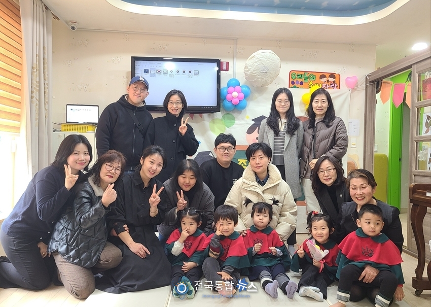 그린어린이집 졸업생일동과 부모님들이 밝게 기념촬영을 하고있다.