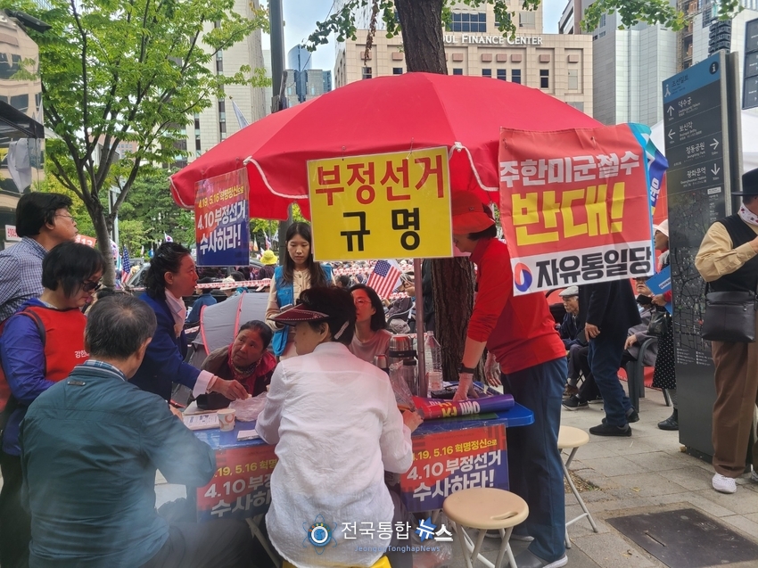부정선거수사의 피켓과 함께 지나가는 시민들을 깨우고 있는 애국 시민들 / 김경옥 기자