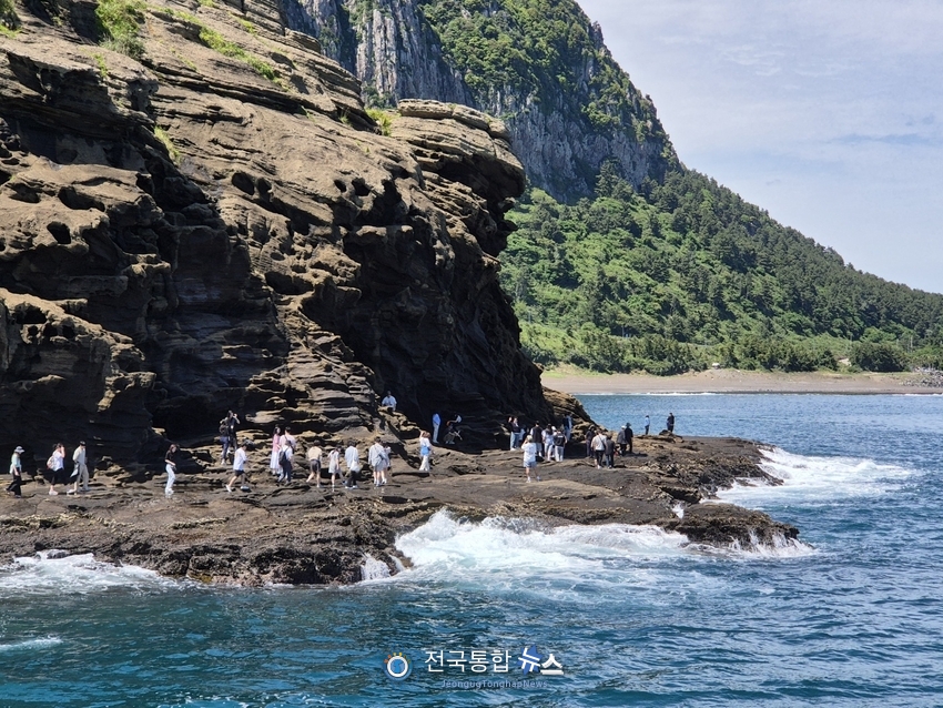 산방산과 바다를 즐기고 있는 관광객들이 배에서 보니 멀리보인다 / 김경옥 기자