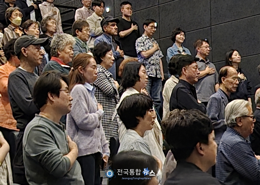 영화 상영중 국민의례를 하고 있는 관객들 / 김경옥 기자