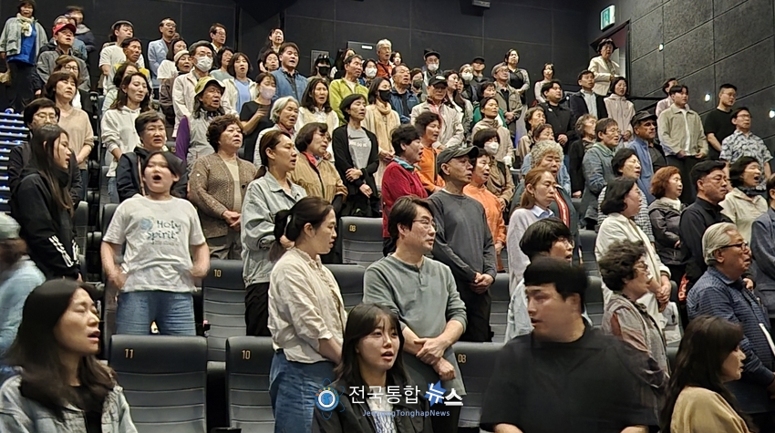 영화상영중 애국가를 부르고 있는 관객들 / 김경옥 기자