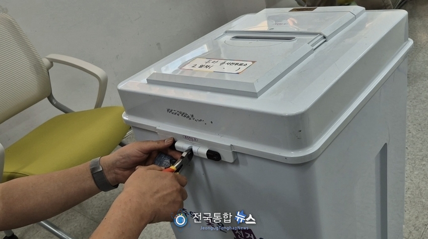 투표후 투표 관리관이 봉인지 제거 후 소형 니빠로 잠금쇠를 절단하고 있다 / 김경옥 기자
