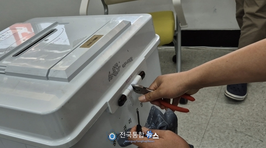 투표 후 잠금쇠를 제거하고 있는 투표관리관 / 김경옥 기자