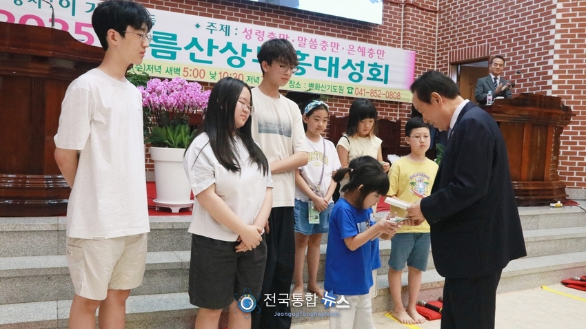 '2025여름산상부흥대성회'에서 참석한 어린이들에게 용돈을 주는 이기복 감독 / 전국통합뉴스=이승주 기자
