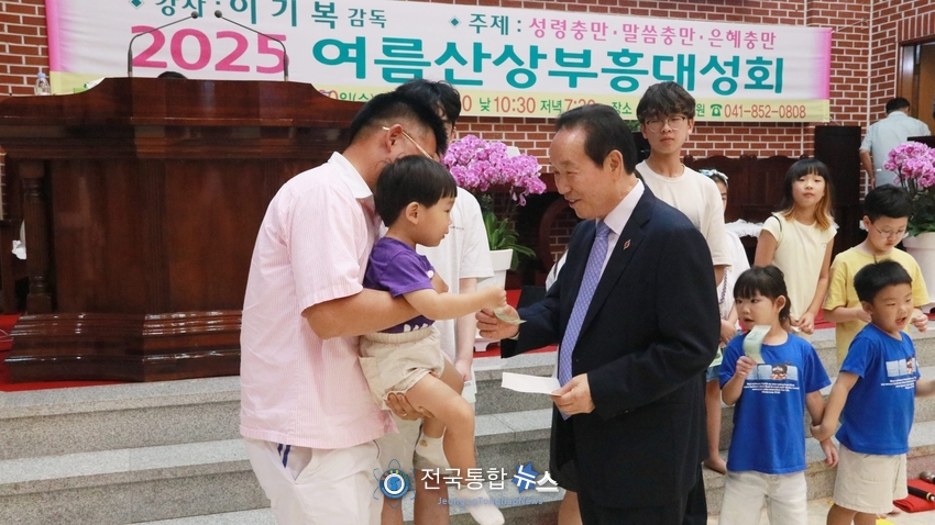 '2025여름산상부흥대성회'에서 참석한 어린이들에게 용돈을 주는 이기복 감독 / 전국통합뉴스=이승주 기자