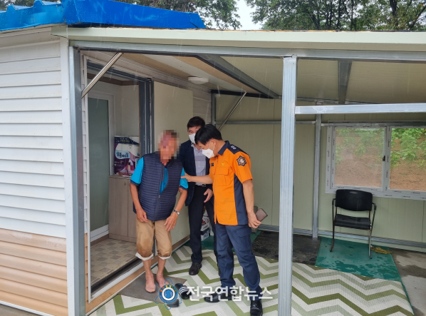 조선호 충남소방본부장(사진 왼쪽)이 새로 마련된 비가림시설로 나오는 김씨를 부축하고 있다.