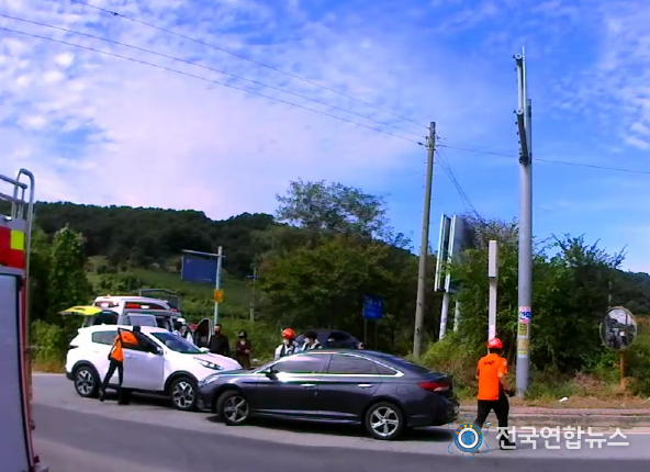 운전불능 상태의 SUV(사진 왼쪽 흰색) 차량을 자신의 차량(사진 가운데 검정색)으로 막아낸 신고자 이 씨가 출동한 소방관들과 함께 환자의 상태를 살피고 있다.